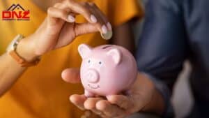 Person inserting coin into piggy bank for savings, representing financial benefits of electrical upg.