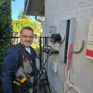 Licensed Electrician Performing Electrical Panel Service Upgrade – DNZ Electrical Services Licensed electrician from DNZ Electrical Services working on electrical meter and service panel upgrade at a home in Agoura Hills